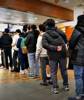 A group of people standing in line at a McDonald's restaurant waiting to order. - Olive Oil Times