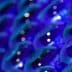 Close-up view of a collection of blue glass bottles arranged in a pattern. - Olive Oil Times