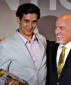 Two men standing together at an award ceremony, one holding a trophy and the other smiling. - Olive Oil Times