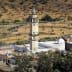 A minaret located in a rural area, surrounded by olive trees and agricultural land. - Olive Oil Times