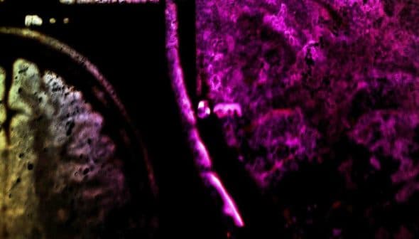 An abstract image featuring a colorful texture with shades of purple, orange, and black. - Olive Oil Times