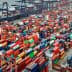 Aerial view of a busy port with numerous shipping containers and a cargo ship docked. - Olive Oil Times