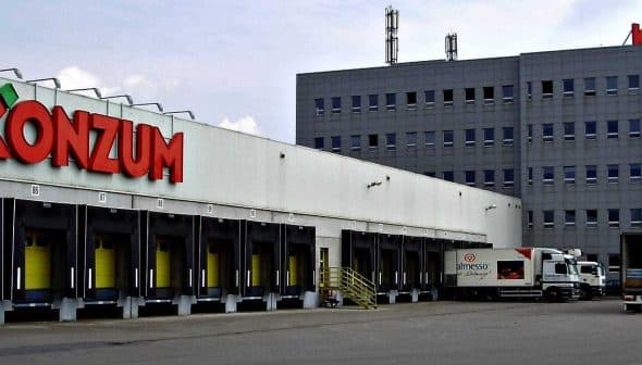 Exterior view of the Konzum distribution center with loading docks and delivery trucks. - Olive Oil Times