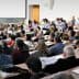 A large audience seated in a lecture hall during a conference presentation. - Olive Oil Times
