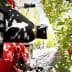 Close-up of a fruit harvesting machine positioned near apple trees in an orchard. - Olive Oil Times
