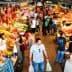 A vibrant market scene featuring various fruits, vegetables, and people shopping. - Olive Oil Times