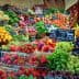 A vibrant assortment of fresh fruits and vegetables arranged at a market stall with price tags. - Olive Oil Times