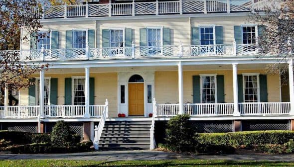 Two-story historic house featuring a large front porch and multiple windows. - Olive Oil Times