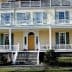 Two-story historic house featuring a large front porch and multiple windows. - Olive Oil Times