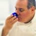 Chef smelling a blue cup during an olive oil tasting session in a professional kitchen. - Olive Oil Times