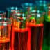 Row of test tubes filled with various colored liquids in a laboratory setting. - Olive Oil Times