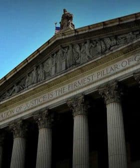 Facade of a New York City courthouse featuring tall columns and sculptures on the roof. - Olive Oil Times