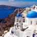 View of Santorini island featuring white buildings with blue domes against the sea. - Olive Oil Times