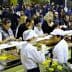 Crowd of people enjoying food at a culinary event with chefs serving dishes. - Olive Oil Times