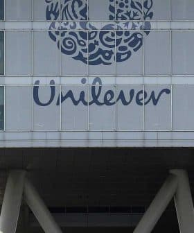 Exterior view of the Unilever headquarters building featuring a large logo and glass facade. - Olive Oil Times