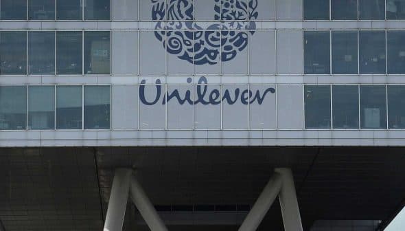 Exterior view of the Unilever headquarters building featuring a large logo and glass facade. - Olive Oil Times