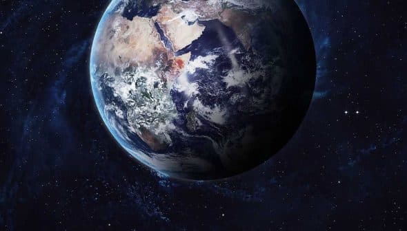 A detailed view of Earth from space, showing landmasses and oceans against a dark background. - Olive Oil Times