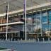 A modern commercial building featuring a glass facade and multiple banners. - Olive Oil Times