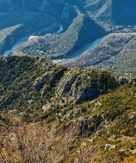 Aerial view of a mountainous landscape featuring a curving river and rocky terrain. - Olive Oil Times