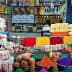 A variety of colorful spices, snacks, and packaged goods arranged in a market setting. - Olive Oil Times