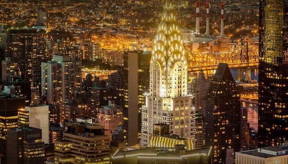Chrysler Building illuminated at night among other skyscrapers in New York City. - Olive Oil Times