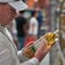 Individual inspecting a bottle of cooking oil while standing in a grocery store aisle. - Olive Oil Times