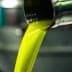 Golden green olive oil pouring from a metal spout in a production facility. - Olive Oil Times