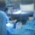 Two medical professionals wearing scrubs and masks working in an operating room with surgical instruments. - Olive Oil Times