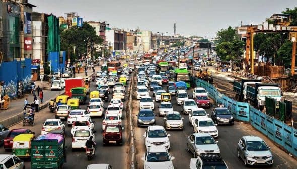 A congested urban street filled with various vehicles including cars, buses, and trucks during daytime. - Olive Oil Times