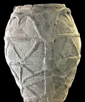 A textured ancient pottery vase with geometric designs and handles on the sides. - Olive Oil Times