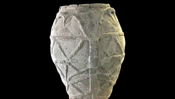 A textured ancient pottery vase with geometric designs and handles on the sides. - Olive Oil Times