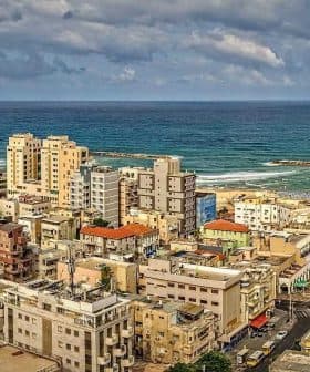 Panoramic view of a coastal city with buildings and the ocean in the background. - Olive Oil Times