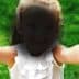 A child with outstretched arms smiling at the camera, wearing a white top with ruffles. - Olive Oil Times