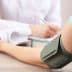 A blood pressure monitor is placed on a patient's arm during a medical consultation. - Olive Oil Times