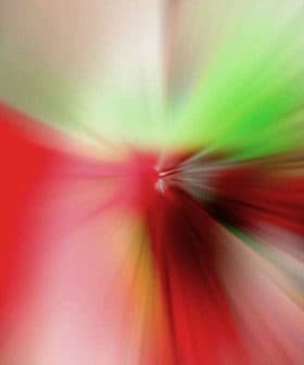 An abstract image featuring a colorful blur of red, green, and other colors radiating from a central point. - Olive Oil Times