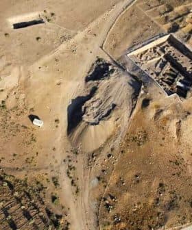 Aerial view of an archaeological site with excavation areas and surrounding terrain. - Olive Oil Times