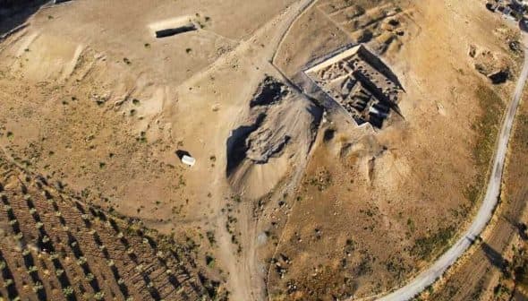Aerial view of an archaeological site with excavation areas and surrounding terrain. - Olive Oil Times