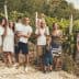 Group of people posing together in a vineyard with grapevines in the background. - Olive Oil Times