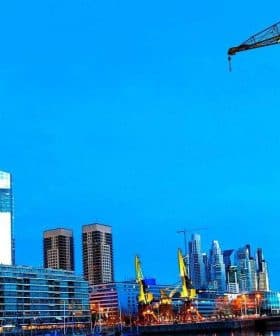 View of the Puerto Madero waterfront in Buenos Aires featuring modern buildings and a crane. - Olive Oil Times