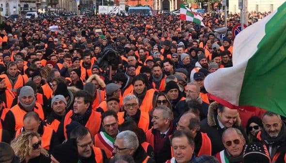 Large crowd of people wearing orange vests during a protest in an urban setting. - Olive Oil Times
