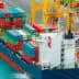 Cargo ship with colorful shipping containers docked at a port. - Olive Oil Times