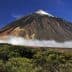 Mount Teide, a prominent volcano in Tenerife, with a snow-capped peak and surrounding clouds. - Olive Oil Times
