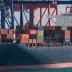 Container ship named Genoa loaded with colorful shipping containers at a port. - Olive Oil Times