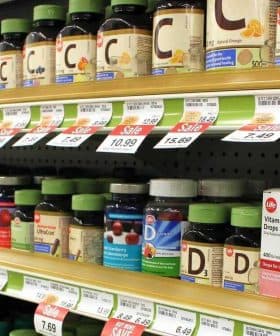 Various bottles of dietary supplements displayed on a store shelf with price tags. - Olive Oil Times