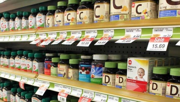 Various bottles of dietary supplements displayed on a store shelf with price tags. - Olive Oil Times