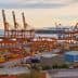 Container port in Piraeus, Athens with cranes and shipping containers along the waterfront. - Olive Oil Times