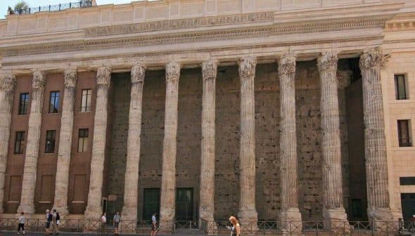 The Temple of Hadrian in Rome features tall columns and a stone facade with a historical architectural design. - Olive Oil Times