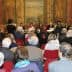 Audience seated in a hall during a literary event with speakers at the front. - Olive Oil Times