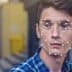 Young man with facial recognition overlay and processing indicator on his face while looking at a device. - Olive Oil Times