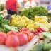 Assorted fresh vegetables including tomatoes, cucumbers, and peppers displayed at a market stall. - Olive Oil Times